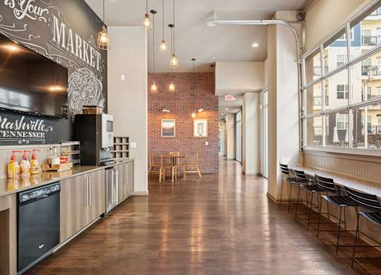 A long hallway with a brick wall and a table in the middle.
