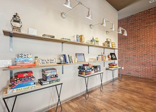 A room with a brick wall and a shelf with books and other items.
