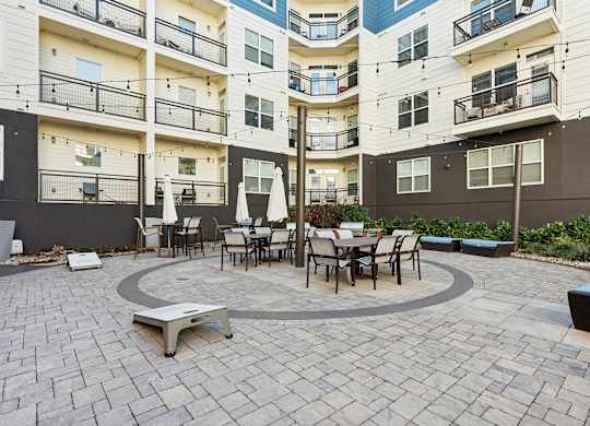 A courtyard with a table and chairs surrounded by apartment buildings.