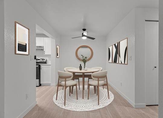 a dining room with a round table and chairs and a ceiling fan