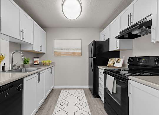 our spacious kitchens are equipped with black appliances and white cabinets