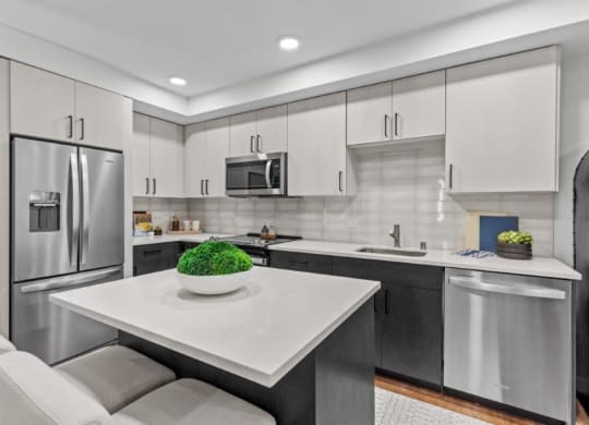 a modern kitchen with stainless steel appliances and a white counter top