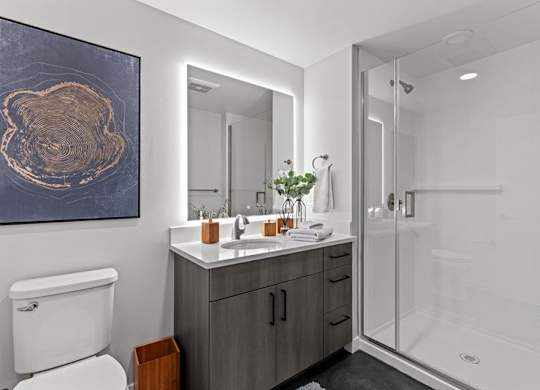 A bathroom with a toilet, sink, and shower.