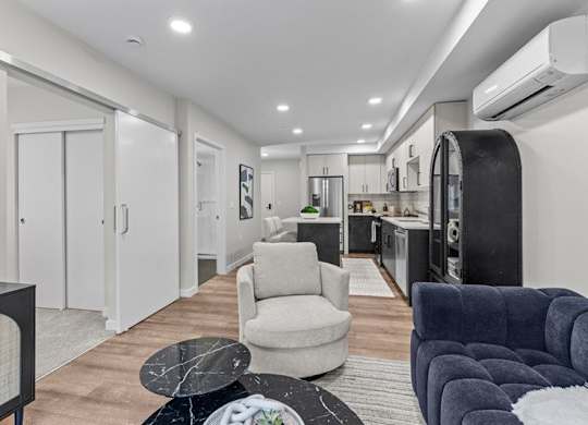 A modern living room with a grey armchair and a blue couch.