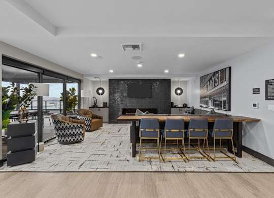 A modern living room with a large TV and comfortable seating.