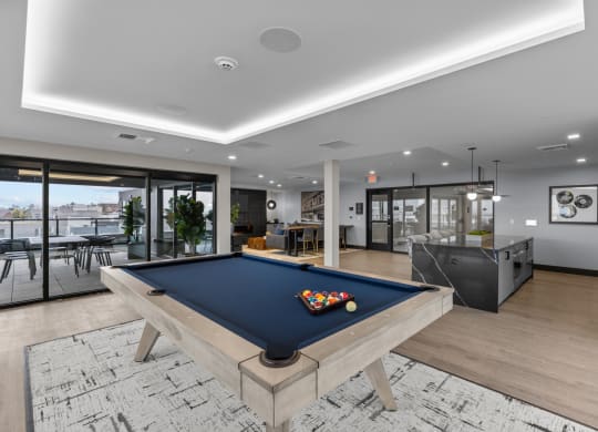 a pool table in a living room with a bar and a television