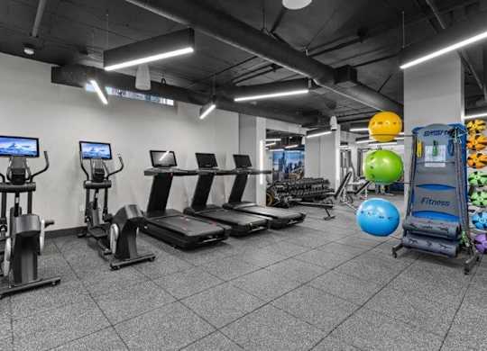 A gym with treadmills, exercise bikes, and a rowing machine.