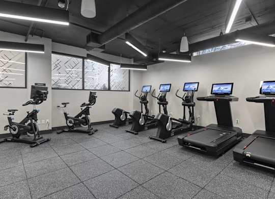 A gym with treadmills, exercise bikes, and elliptical machines.