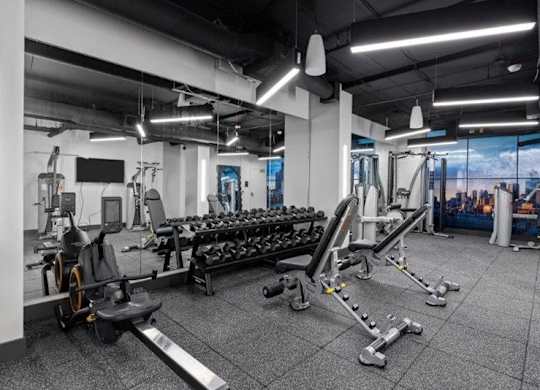 A gym with a variety of equipment including weights and machines.
