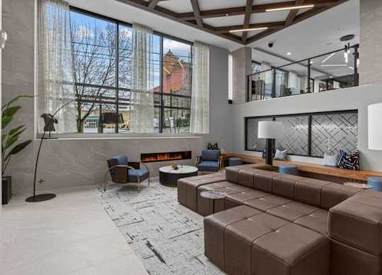 A modern living room with a large window and a fireplace.