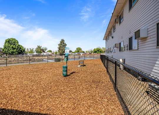 A baseball field with a green sign and a fence.