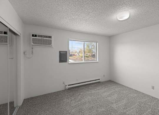 A room with a window and two air conditioning units.