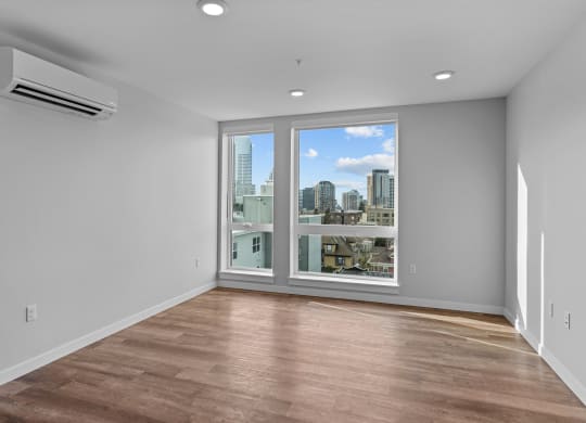 an empty living room with a window and a city view