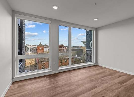 A room with a large window overlooking a cityscape.