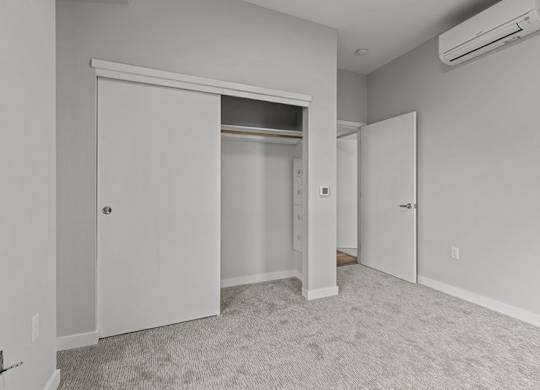 A room with a carpeted floor and a sliding door.
