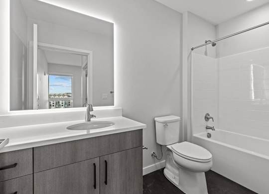 A white bathroom with a toilet, sink, and bathtub.
