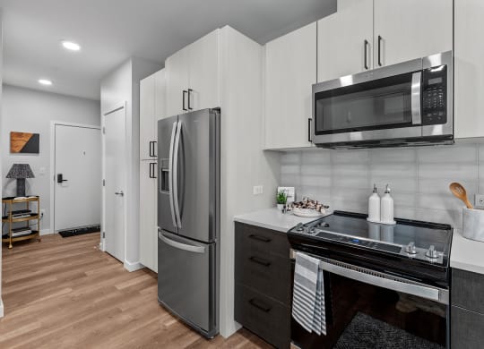 Gridline Apartments Kitchen with Stainless Steel Fridge and Entryway
