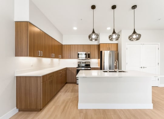 a kitchen with a large white island and wooden cabinets
