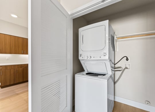 a laundry room with a washer and dryer and a door to a kitchen