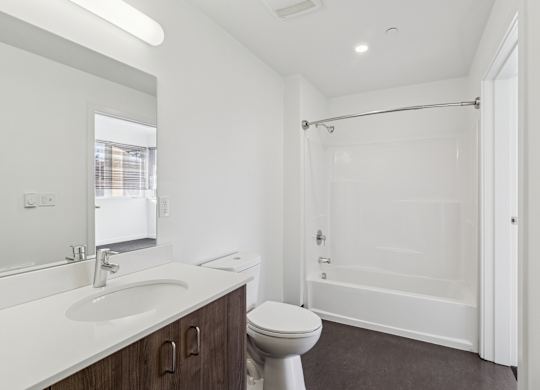 A white bathroom with a toilet, sink, and shower.