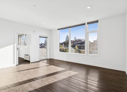 A large empty room with a view of the outside through the windows.