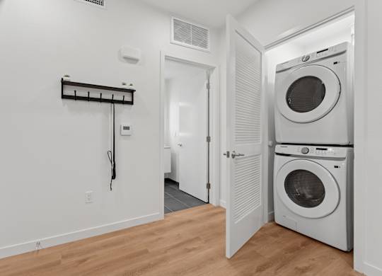 OnyxOnPark_SanDiego_CA_Model_1BR_ A laundry room with a washer and dryer.