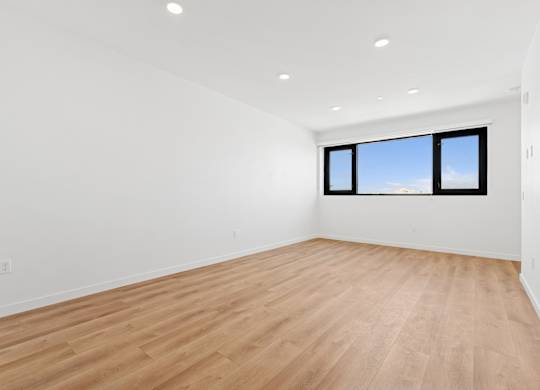 OnyxOnPark_SanDiego_CA_Vacant_2BR_ A room with wooden flooring and a window.