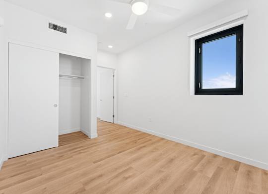 OnyxOnPark_SanDiego_CA_Vacant_2BR_ A room with a window and a ceiling fan.