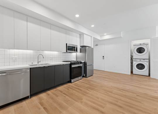 OnyxOnPark_SanDiego_CA_Vacant_2BR_ A modern kitchen with wooden floors and stainless steel appliances.