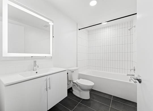 OnyxOnPark_SanDiego_CA_Vacant_2BR_ A white bathroom with a toilet, sink, and bathtub.