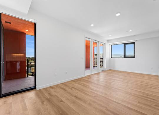 OnyxOnPark_SanDiego_CA_Vacant_2BR_B1_A spacious room with wooden flooring and a large window.