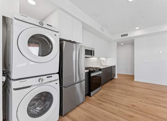 OnyxOnPark_SanDiego_CA_Vacant_2BR_B1_A stack of white washing machines in a laundry room.