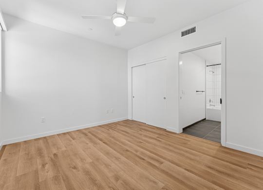 OnyxOnPark_SanDiego_CA_Vacant_2BR_B1_A room with a ceiling fan and wooden flooring.
