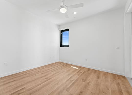 OnyxOnPark_SanDiego_CA_Vacant_2BR_B1_A room with a wooden floor and a ceiling fan.