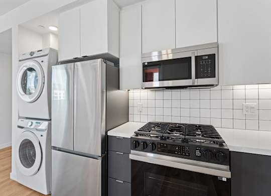 OnyxOnPark_SanDiego_CA_Vacant_2BR_B1_A modern kitchen with a stove, oven, and microwave.