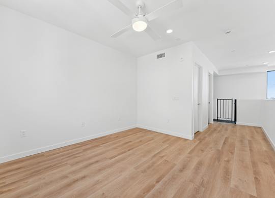 OnyxOnPark_SanDiego_CA_Vacant_Penthouse_A_A room with wooden flooring and white walls.
