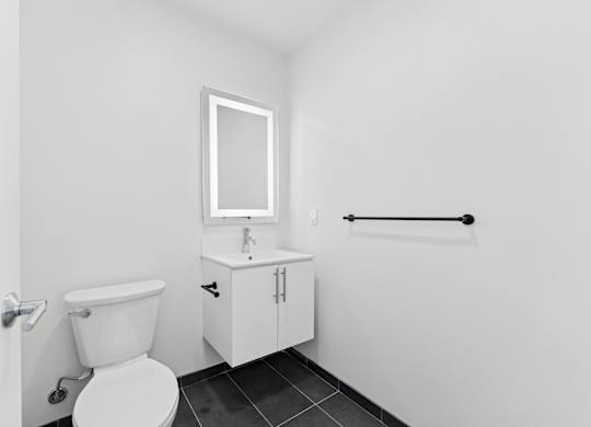 OnyxOnPark_SanDiego_CA_Vacant_Penthouse_A_OnyxOnPark_SanDiego_CA_Vacant_Penthouse_A_A white toilet sits next to a sink in a small bathroom.