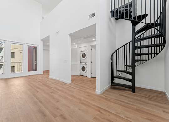 OnyxOnPark_SanDiego_CA_Vacant_Penthouse_A_A black spiral staircase in a white room with wooden flooring.