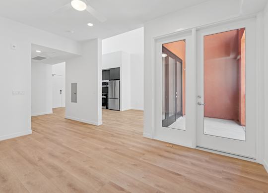OnyxOnPark_SanDiego_CA_Vacant_Penthouse_A_A white room with a wooden floor and a glass door.