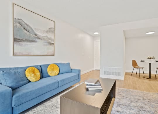 a living room with a blue couch and a table and chairs