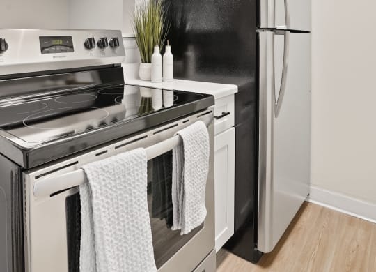 a renovated kitchen with white cabinets and stainless steel appliances and a refrigerator