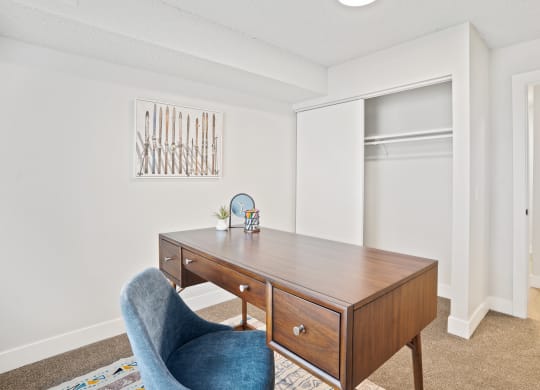 a bedroom with a desk and a chair and a closet