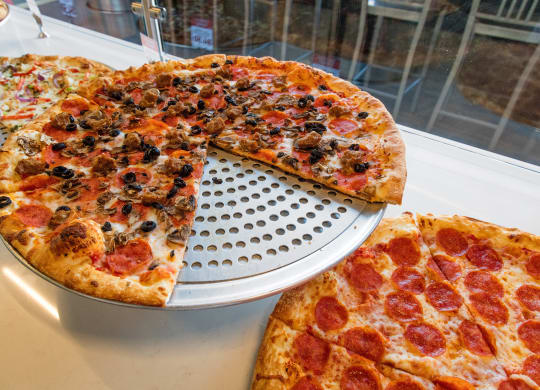 a pepperoni pizza with a slice cut out of it on a pizza pan