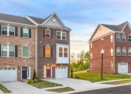 A row of houses with garages and driveways.