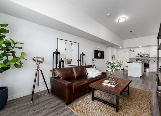 A living room with a brown leather couch and a wooden coffee table.