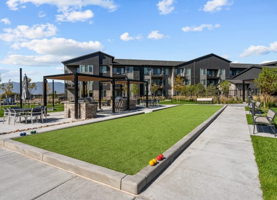 a yard with lawn chairs and a building in the background