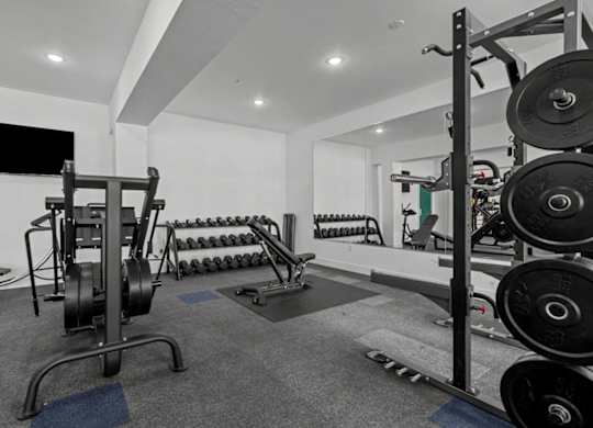 A black and white photo of a gym with weights and exercise equipment.
