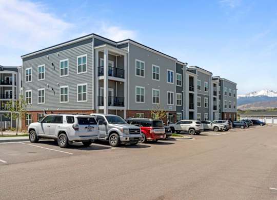 A parking lot with cars and a building in the background.