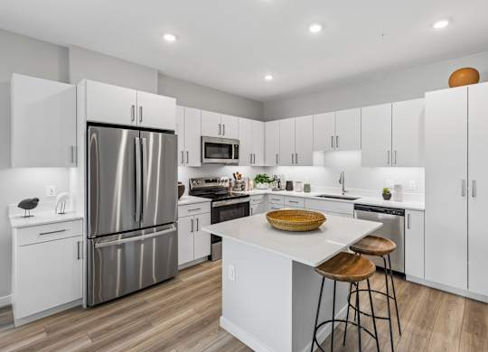 A modern kitchen with white cabinets and a central island.