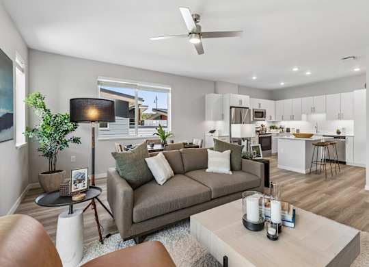 A living room with a grey couch and a brown leather chair.